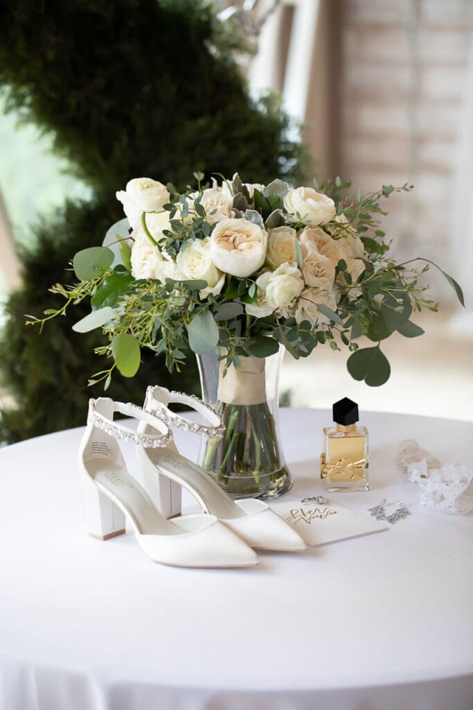 white rose bouquet with bridal shoes and perfume